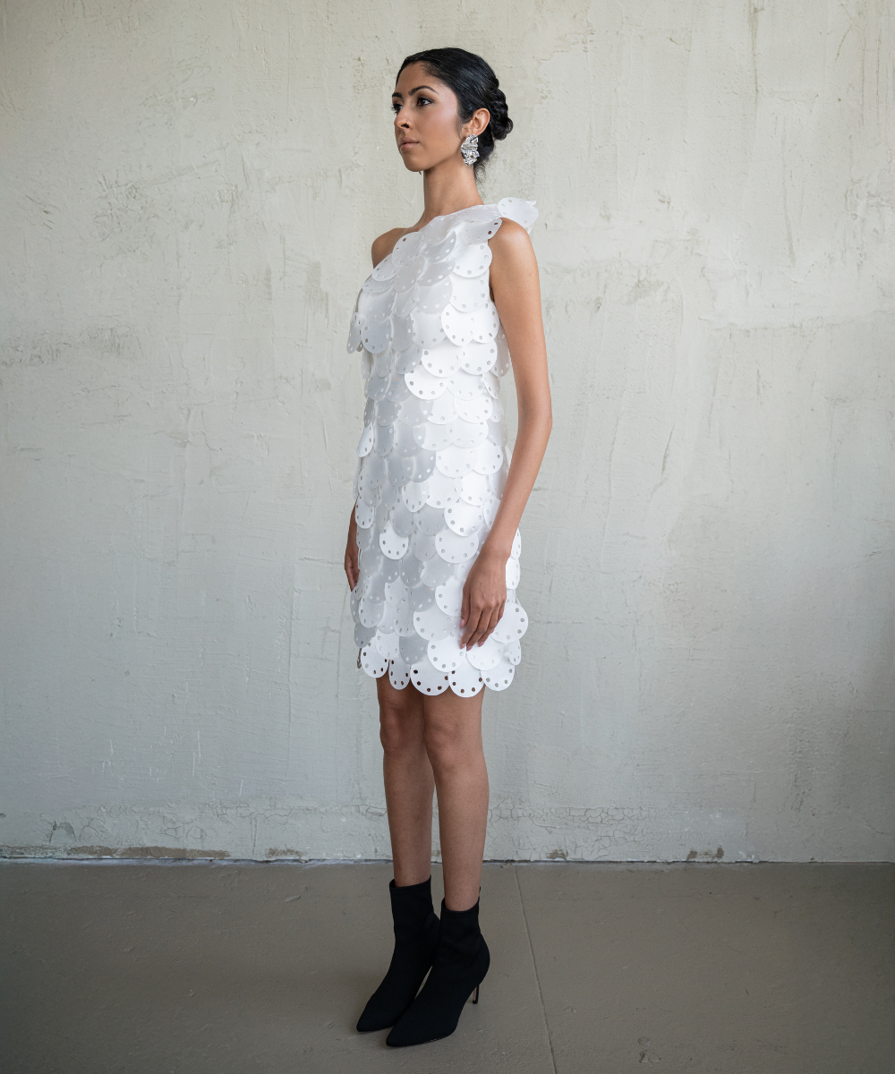 Woman wearing a white lace dress against a plain background